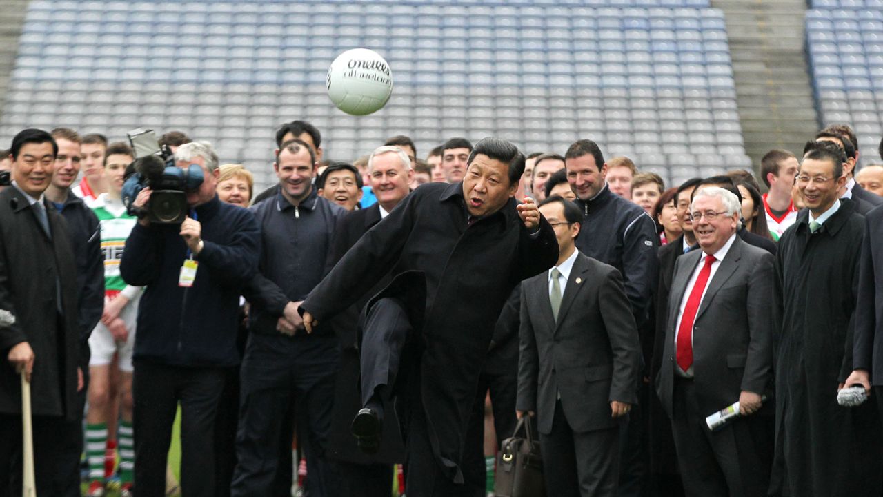 Chinese Vice President Xi Jinping (C) kicks a Gaelic football as he visits at Croke Park in Dublin, Ireland on February 19, 2012.