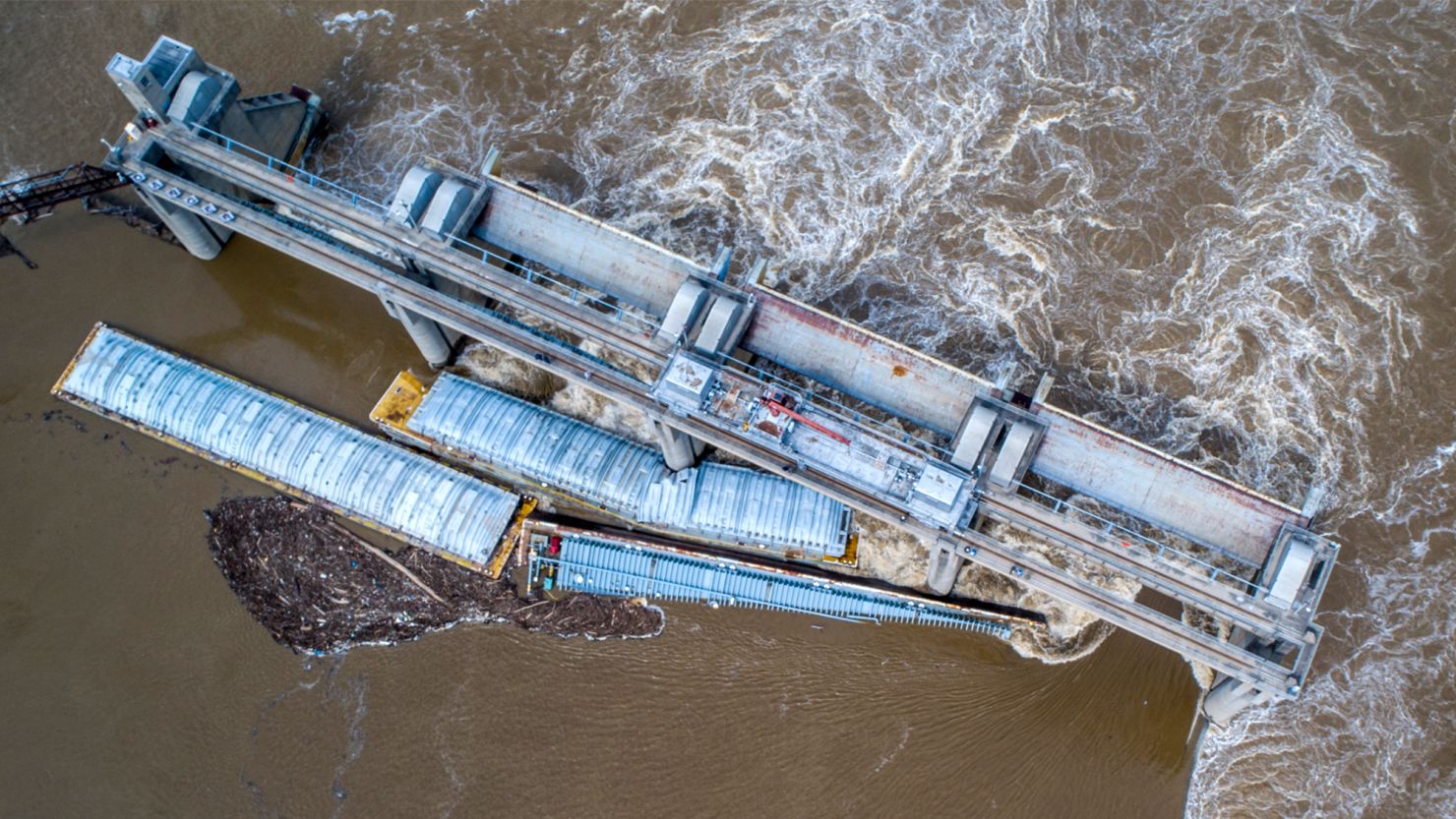 Two barges stuck in the Ohio River; one has been removed, while the other remains.
