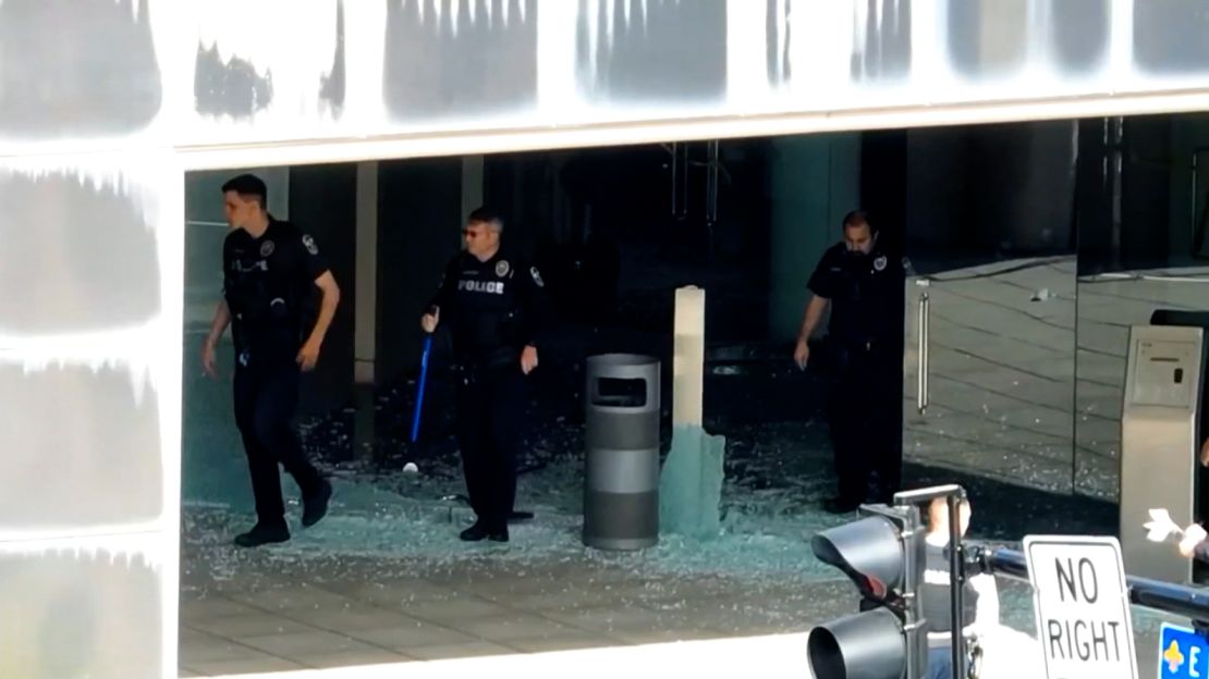 Police step on shattered glass at the Old National Bank in Louisville, Kentucky, on Monday after a mass shooting.