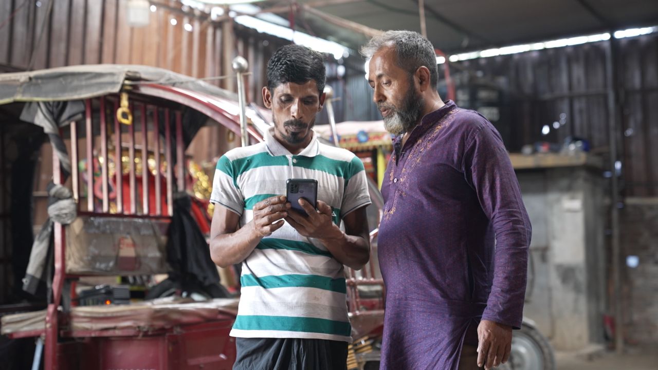Muhammad Delwar Hossain (right) is a tuk-tuk driver in Dhaka.  He started using the smart battery one year ago.