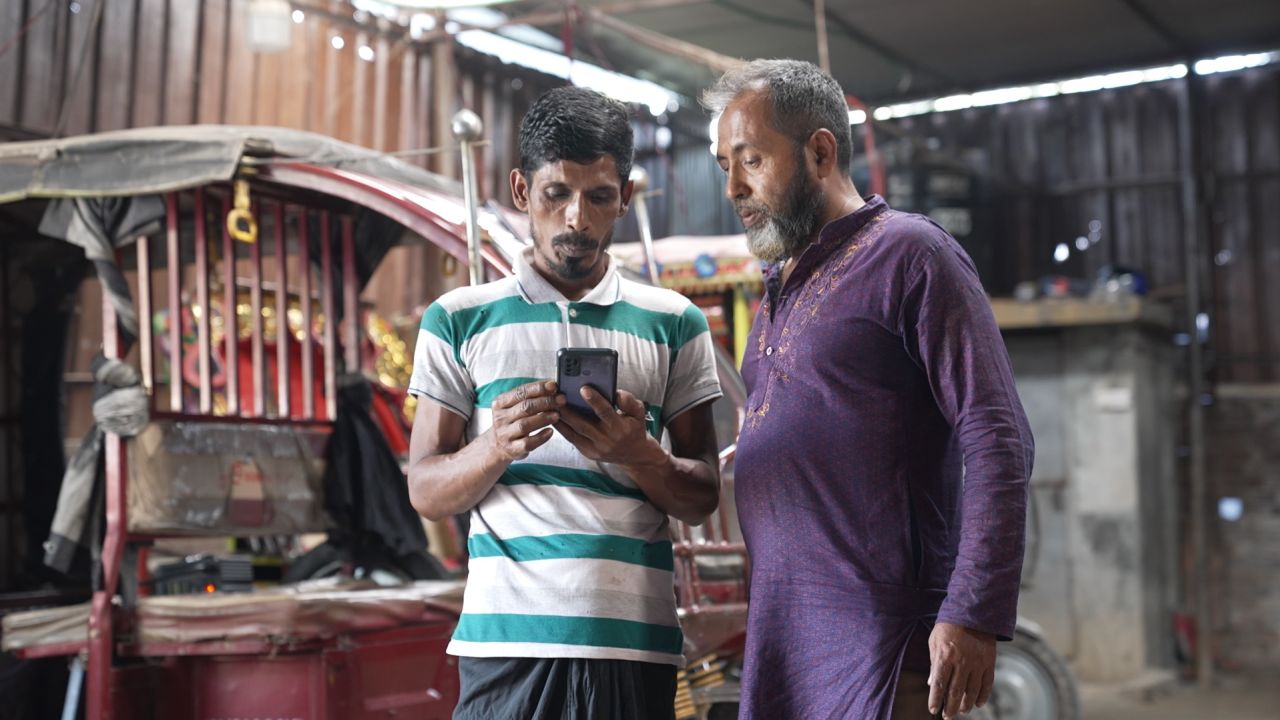 Muhammad Delwar Hossain (right) is a tuk-tuk driver in Dhaka. He started using the smart battery one year ago.