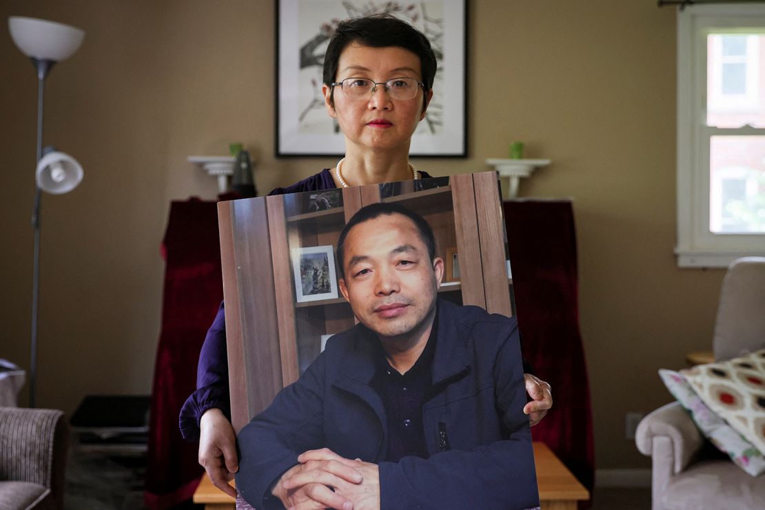 Luo Shengchun, the wife of jailed Chinese human rights lawyer, Ding Jiaxi, poses with a photo of him at her home in New York on July 28, 2022. 