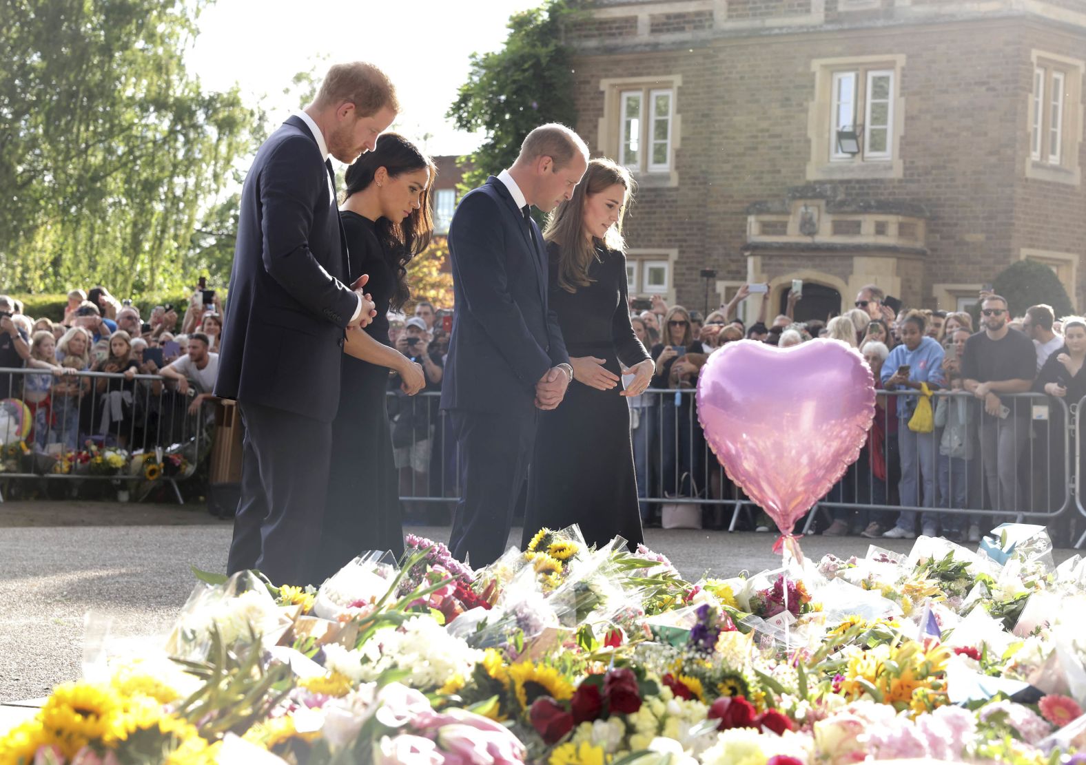 William and Catherine join Prince Harry and Meghan, the Duchess of Sussex, as they view tributes to Queen Elizabeth II outside Windsor Castle in September 2022. It was the first time the public had seen the two brothers together since the Queen's Platinum Jubilee celebrations.