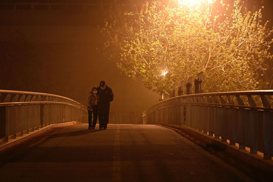 People walk on an overpass during a sandstorm in Beijing on April 10, 2023.