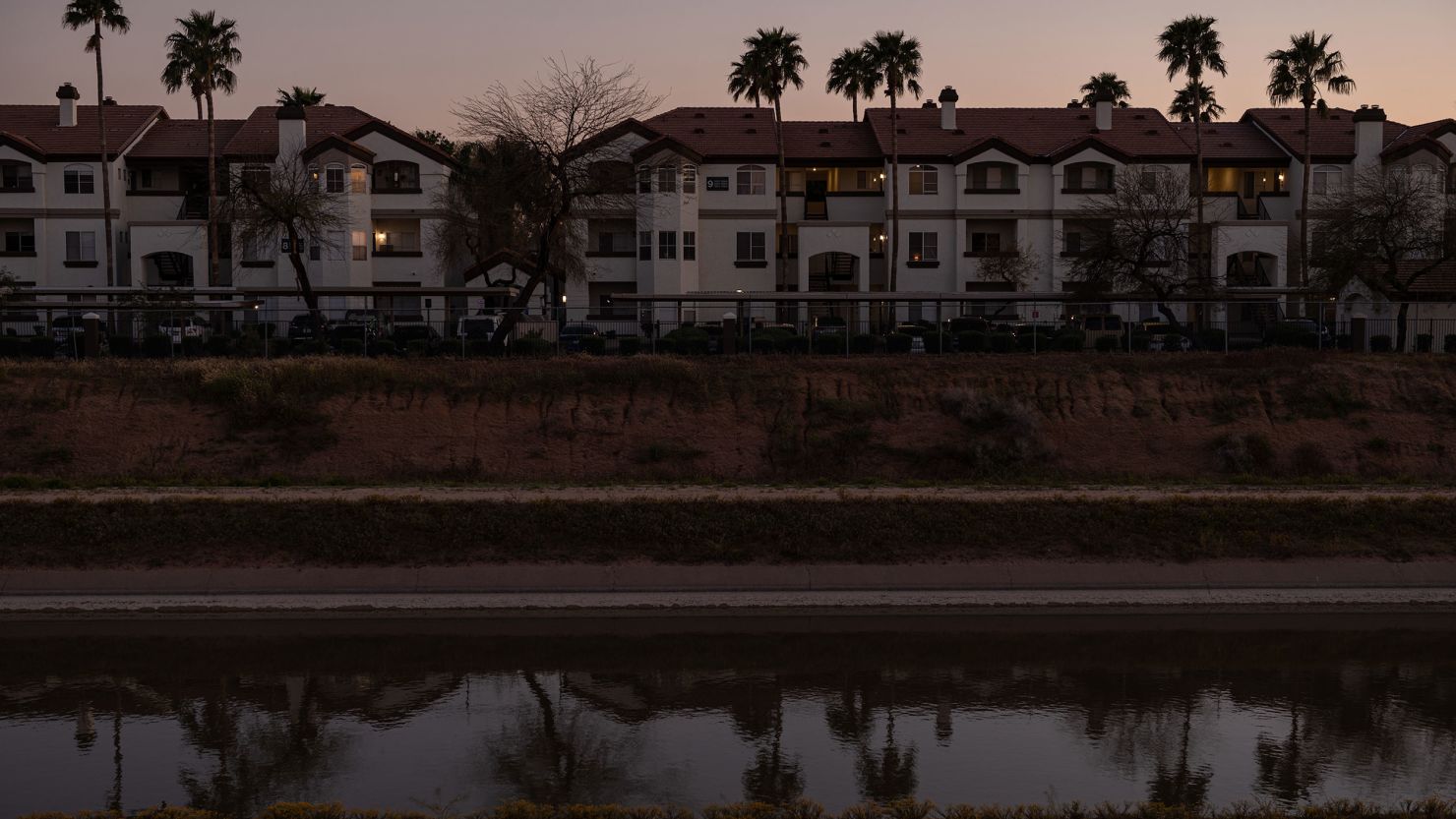 Palm trees and homes are reflected in the Central Arizona Project canal in Phoenix on April 6. The canal delivers Colorado River water to millions of people in Arizona. 