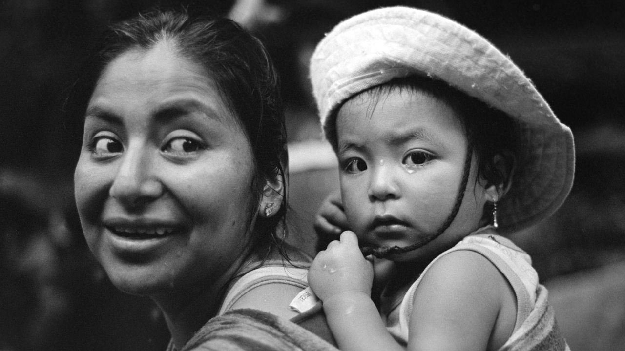 A Peruvian woman and baby pause for a moment on the trek. "It has been calm but tiring. We had food but we don't anymore," she said.