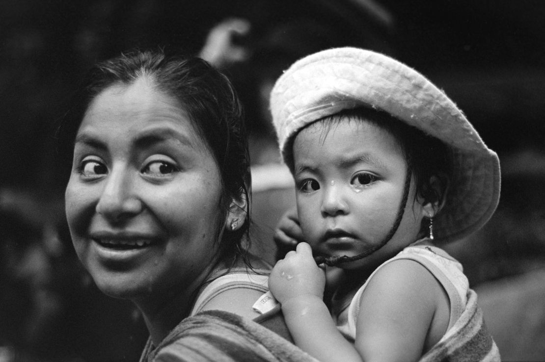 A Peruvian woman and baby pause for a moment on the trek. "It has been calm but tiring. We had food but we don't anymore," she said.