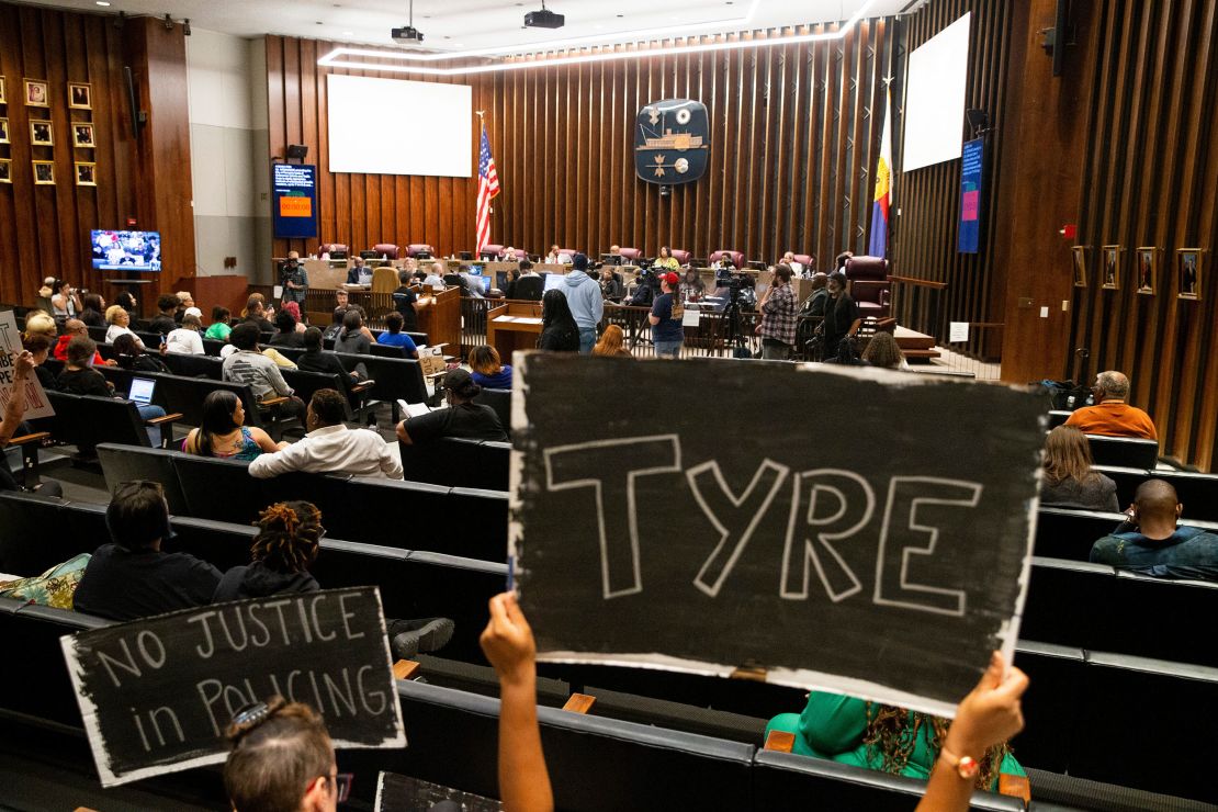 Audience members hold up "no justice in policing" signs honoring Tyre Nichols during a Memphis City Council meeting on April 11, 2023. 