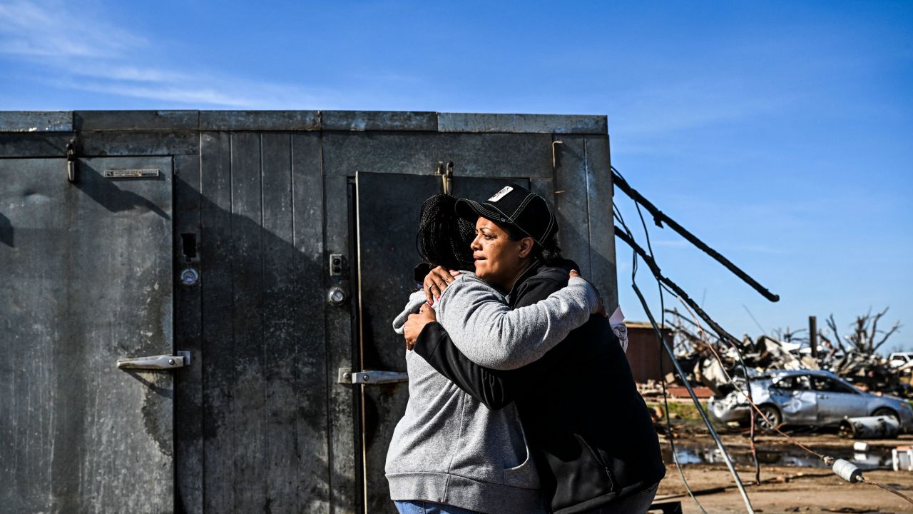 Tracy Harden (Right) hugs Barbara Nell McReynolds-Pinkins near the walk-in cooler where they and seven others took shelter as a tornado destroyed Harden's restaurant in Rolling Fork, Mississippi.