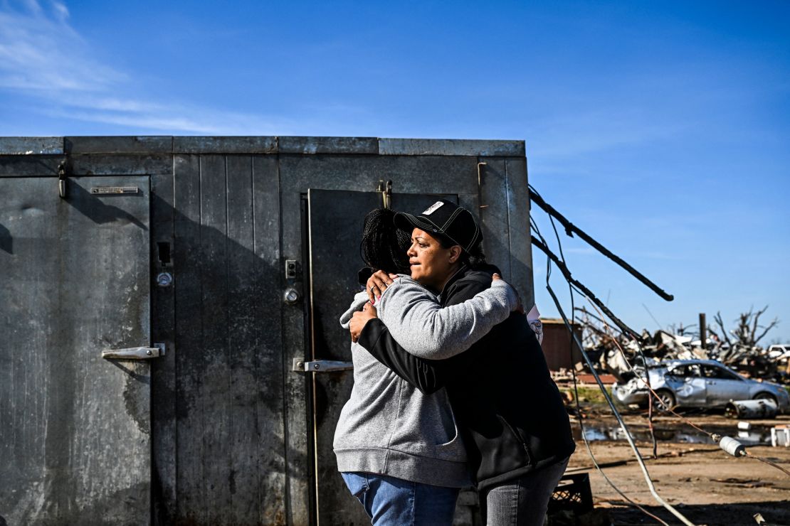 Tracy Harden (Right) hugs Barbara Nell McReynolds-Pinkins near the walk-in cooler where they and seven others took shelter as a tornado destroyed Harden's restaurant in Rolling Fork, Mississippi.