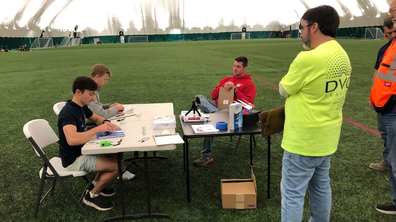 Ruble (from left) and Erickson fold their paper airplanes with witnesses overseeing. The engineers had to pay careful attention to the numerous rules and guidelines set forth by the Guinness World Record Team.