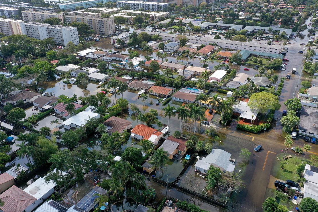 In this aerial view, cars navigate through flooded streets after record rain on April 13, 2023, in Hollywood, Florida. 