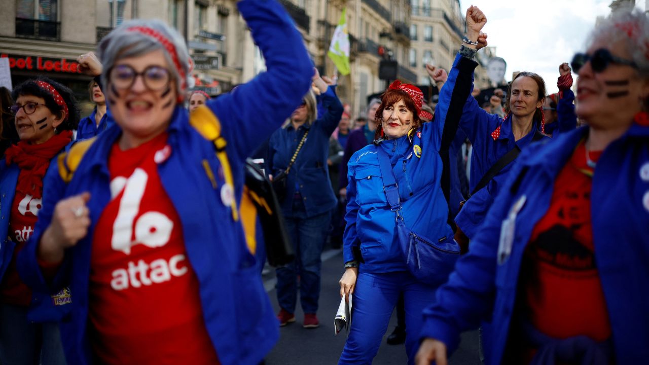 Femimist activists dressed as Rosie the Riveter icon perform during a demonstration in Paris on April 13, 2023. 