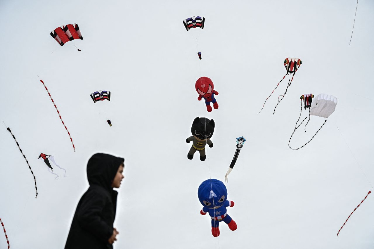 A boy in Châtelaillon-Plage, France, walks beneath flying kites during the International Kite and Wind Festival on Monday, April 10.