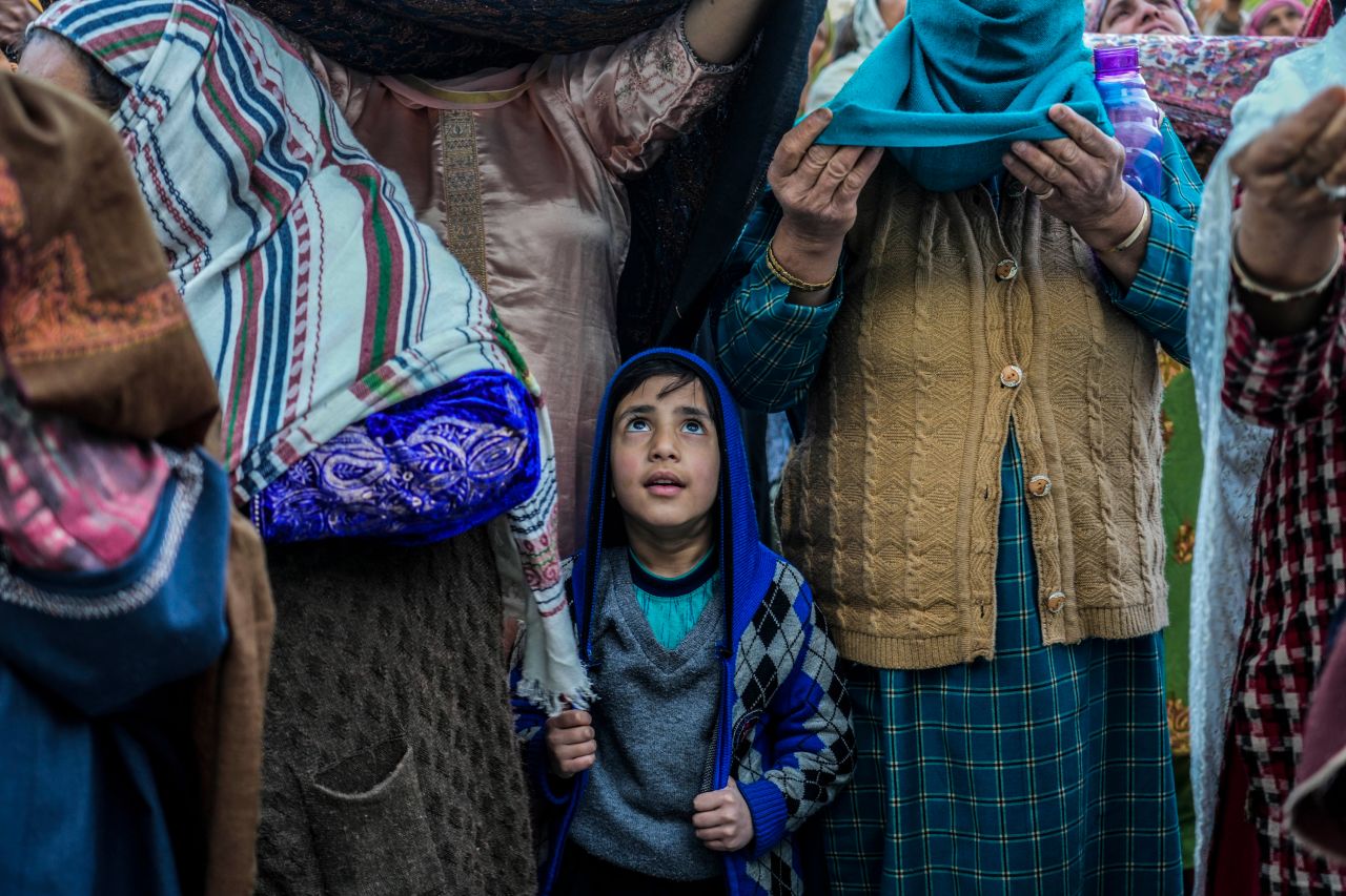 A boy stands with elders at the Hazratbal Shrine in Srinagar, India, as a head priest displays a holy relic believed to be a hair from the beard of the Prophet Muhammad on Wednesday, April 12. This was during special prayers to observe the martyr day of Hazrat Ali, the fourth caliph of Islam.