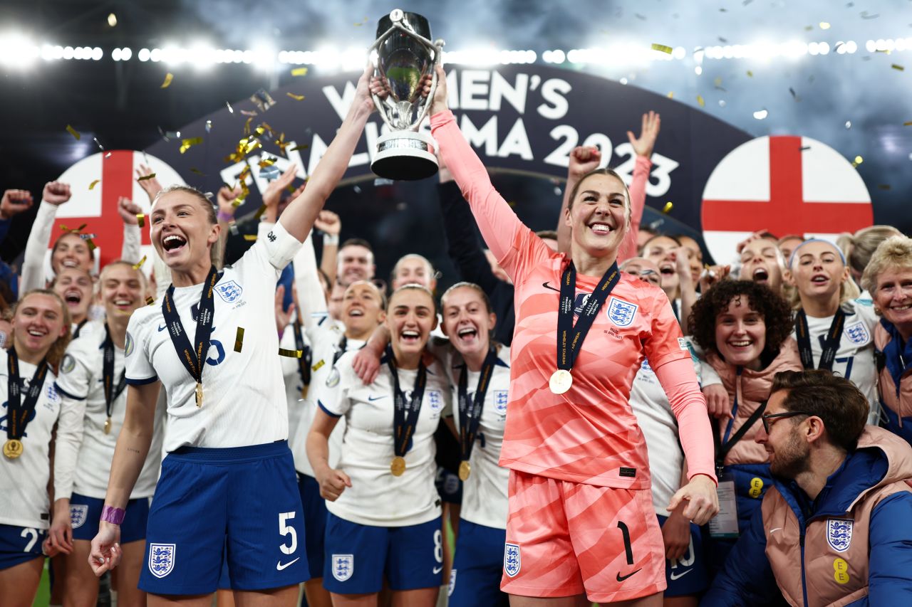 English footballers Leah Williamson, left, and Mary Earps lift the Women's Finalissima trophy after defeating Brazil in London on Thursday, April 6. The match, which pitted Europe's champions versus South America's, was decided by penalties after ending 1-1.