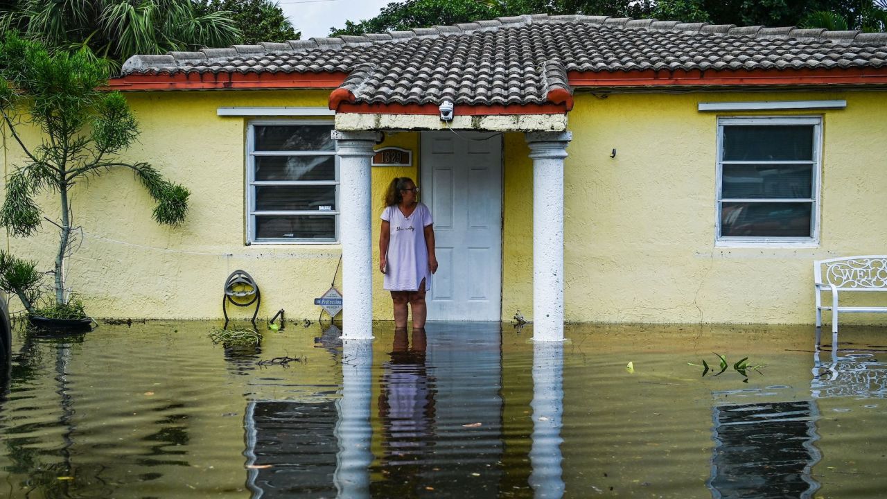 A woman looks on as she stands outside of a flooded home after heavy rain in Fort Lauderdale, Florida on April 13, 2023.
