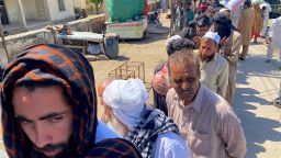 People line up outside a flour distribution center to get free flour handouts from the government in Islamabad.
