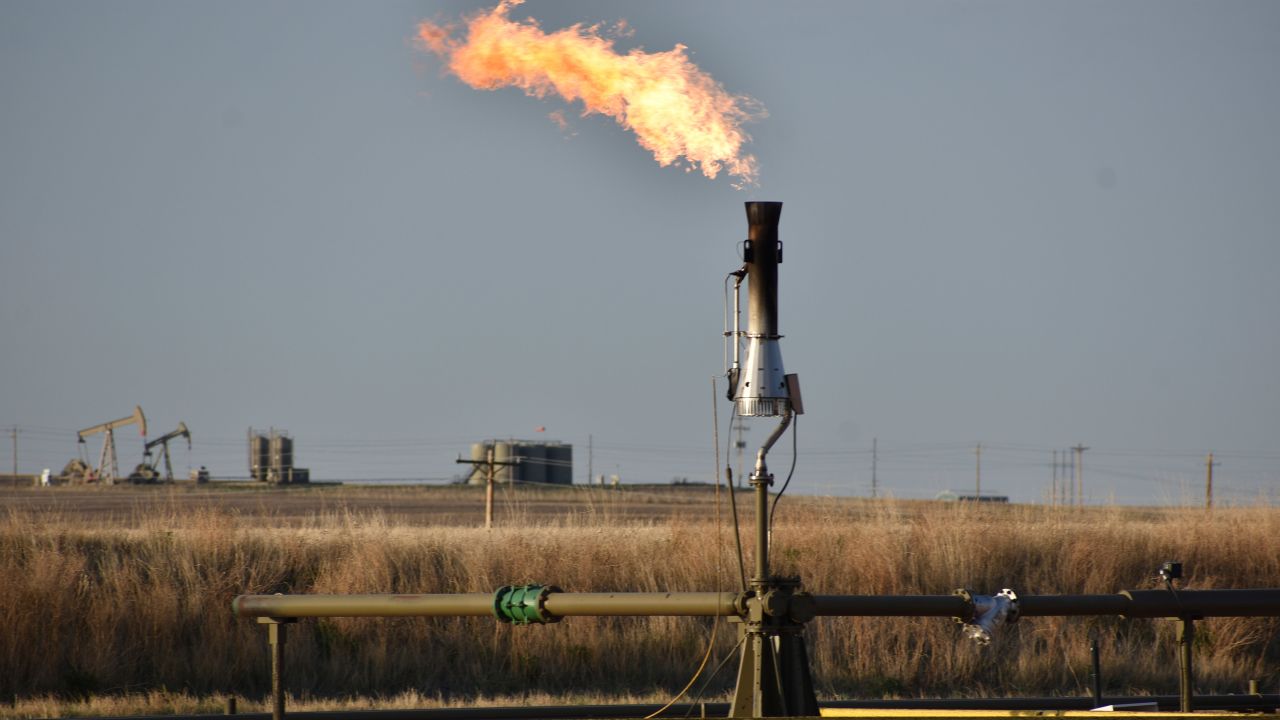 A flare for burning excess methane from crude oil production is seen at a well pad east of New Town, North Dakota in 2021.