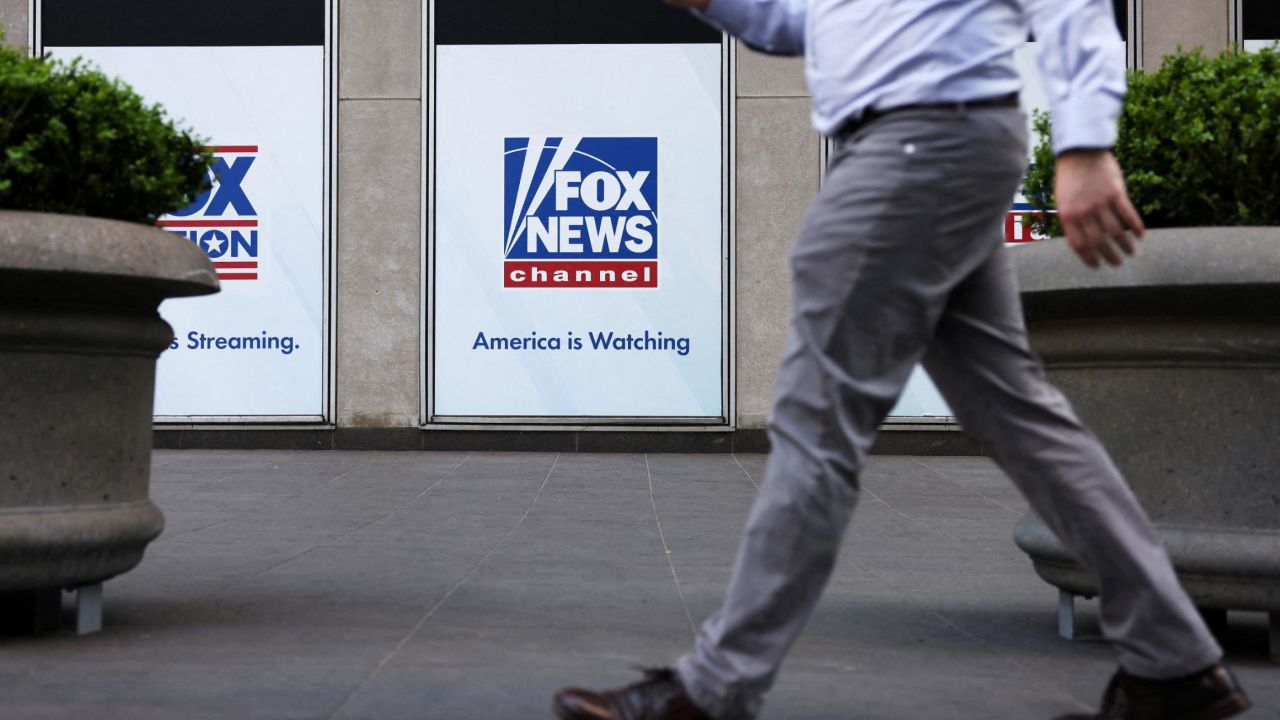 A person walks by Fox News signage posted on the News Corporation building in New York City, on April 12, 2023.
