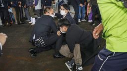 A man, believed to be a suspect who threw a pipe-like object near Japanese Prime Minister Fumio Kishida during his outdoor speech, is held by police officers at Saikazaki fishing port in Wakayama, Wakayama Prefecturein, south-western Japan April 15, 2023, in this photo released by Kyodo. Mandatory credit Kyodo via REUTERS ATTENTION EDITORS - THIS IMAGE WAS PROVIDED BY A THIRD PARTY. MANDATORY CREDIT. JAPAN OUT. NO COMMERCIAL OR EDITORIAL SALES IN JAPAN