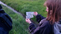 A woman holds cash on the side of Interstate-5 after a man tossed bills from his car in Oregon on Tuesday.