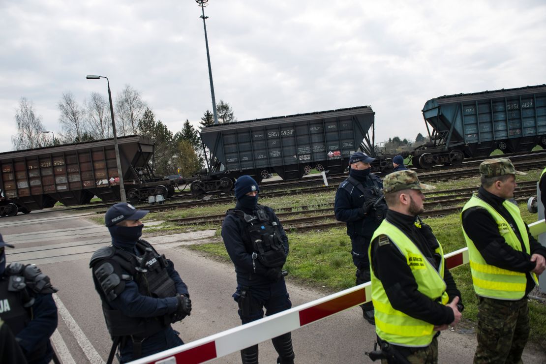 Policemen and border guards protect a train carrying Ukrainian grain at the broad-gauge railway line crossing in Hrubieszow, Poland, on April 12, 2023. 