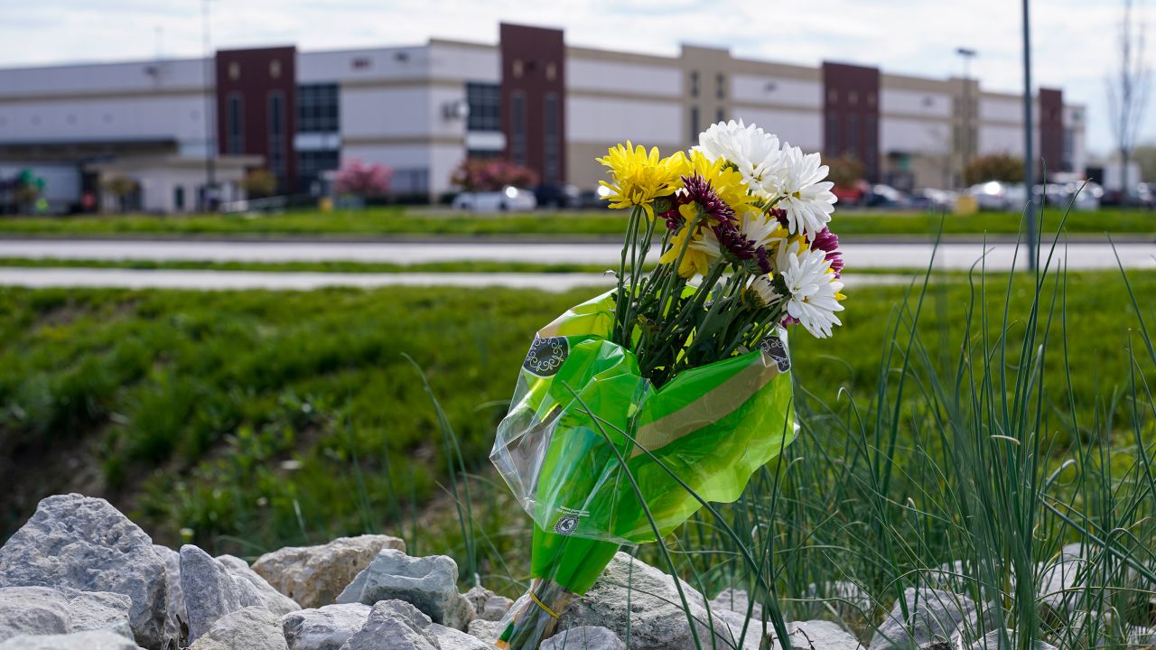 A single bouquet of flowers lies on the rocks across the street from the FedEx facility in Indianapolis, April 17, 2021, where eight people were shot and killed. 