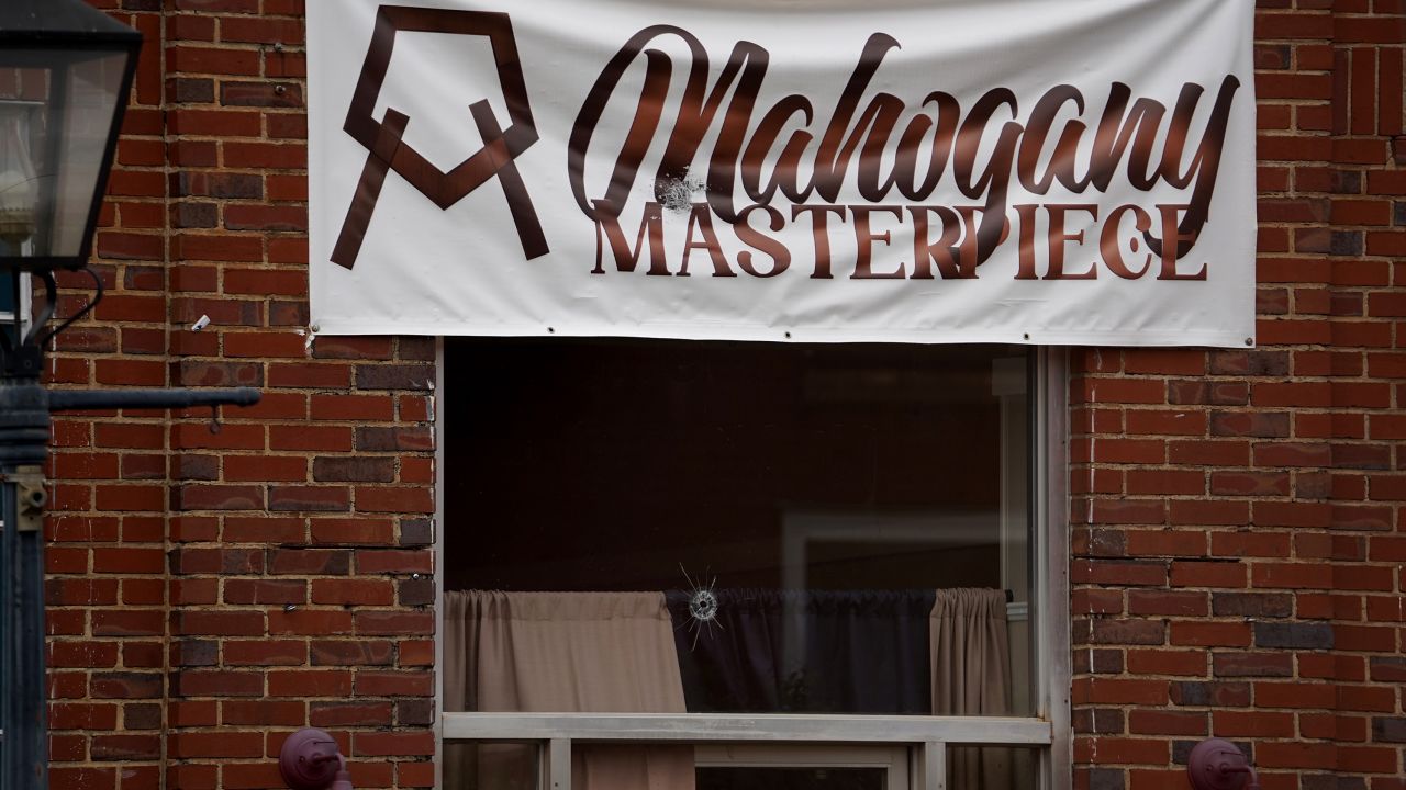 A bullet hole can be seen in a window at the scene of a mass shooting in Dadeville, Alabama.