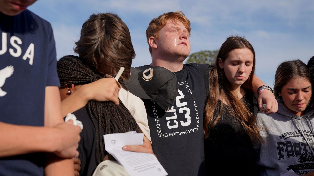 Mourners embrace each during a vigil for the victims of the birthday party shooting in Dadeville, Alabama.