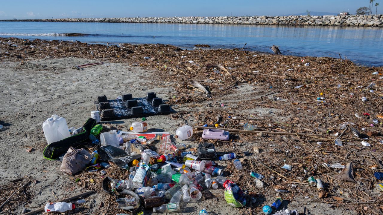 Trash piles up along the bank of the San Gabriel River near the Pacific Ocean in Seal Beach, California. Rains sent the trash flowing down river from miles inland. 