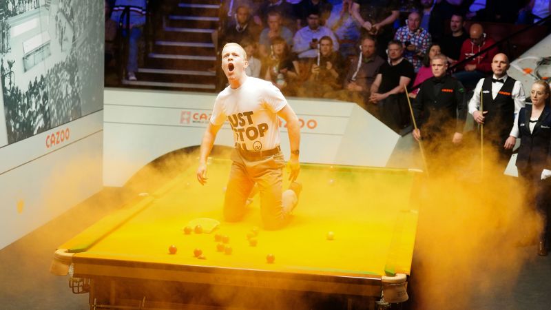 Just Stop Oil protester disrupts World Snooker Championship by throwing orange powder paint on table | CNN