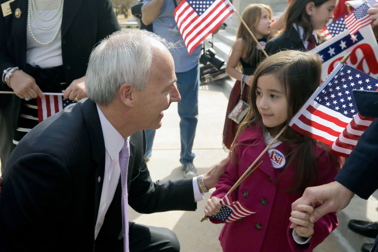 Hutchinson, running for governor again, talks to 5-year-old Addison Mhoon after a speech at the Arkansas State Capitol in February 2014.