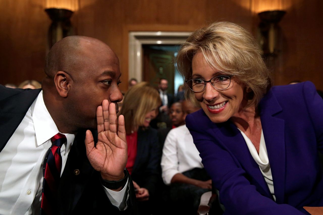 Scott chats with Betsy DeVos at her confirmation hearing to become the next education secretary in January 2017.