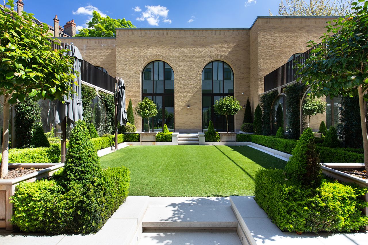 A private back garden leads to the two-story Mews House for welcoming and hosting guests.