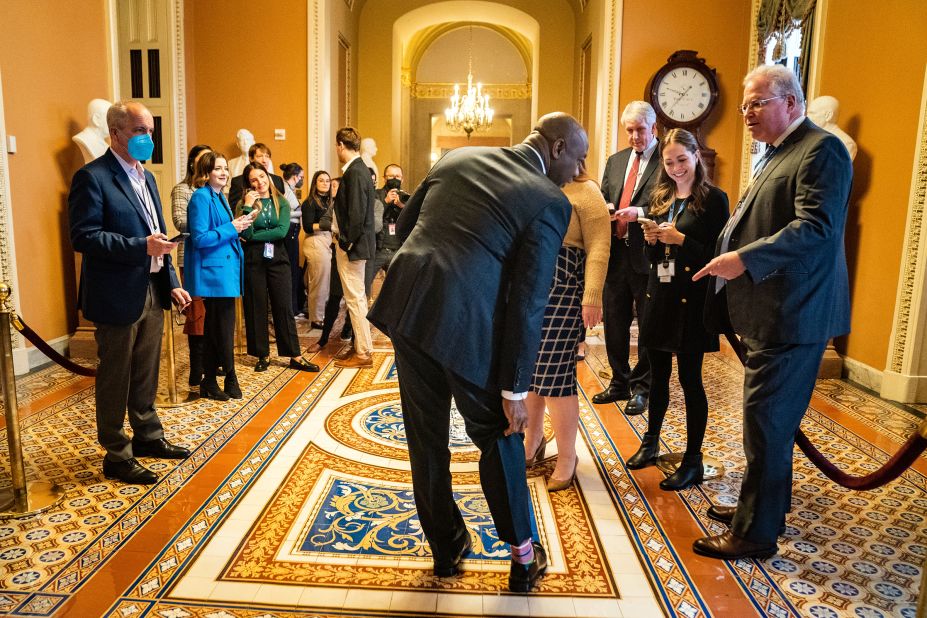 Scott shows his socks to a reporter as he arrives for a meeting with fellow Senate Republicans in November 2022.
