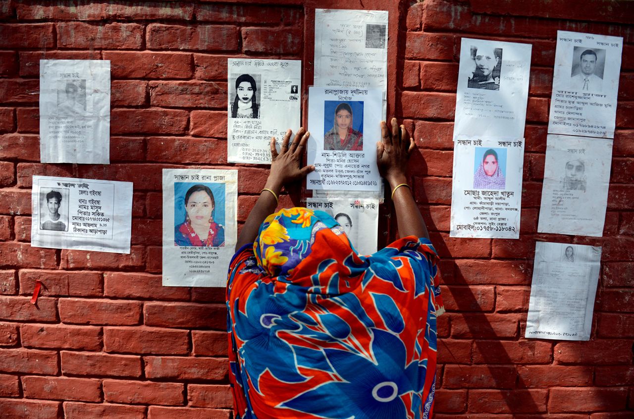 A woman grieves before a poster of her family member on the wall of a school turned into a make-shift morgue on April 30, 2013, following the Rana Plaza collapse in in Savar, near Dhaka, Bangladesh.