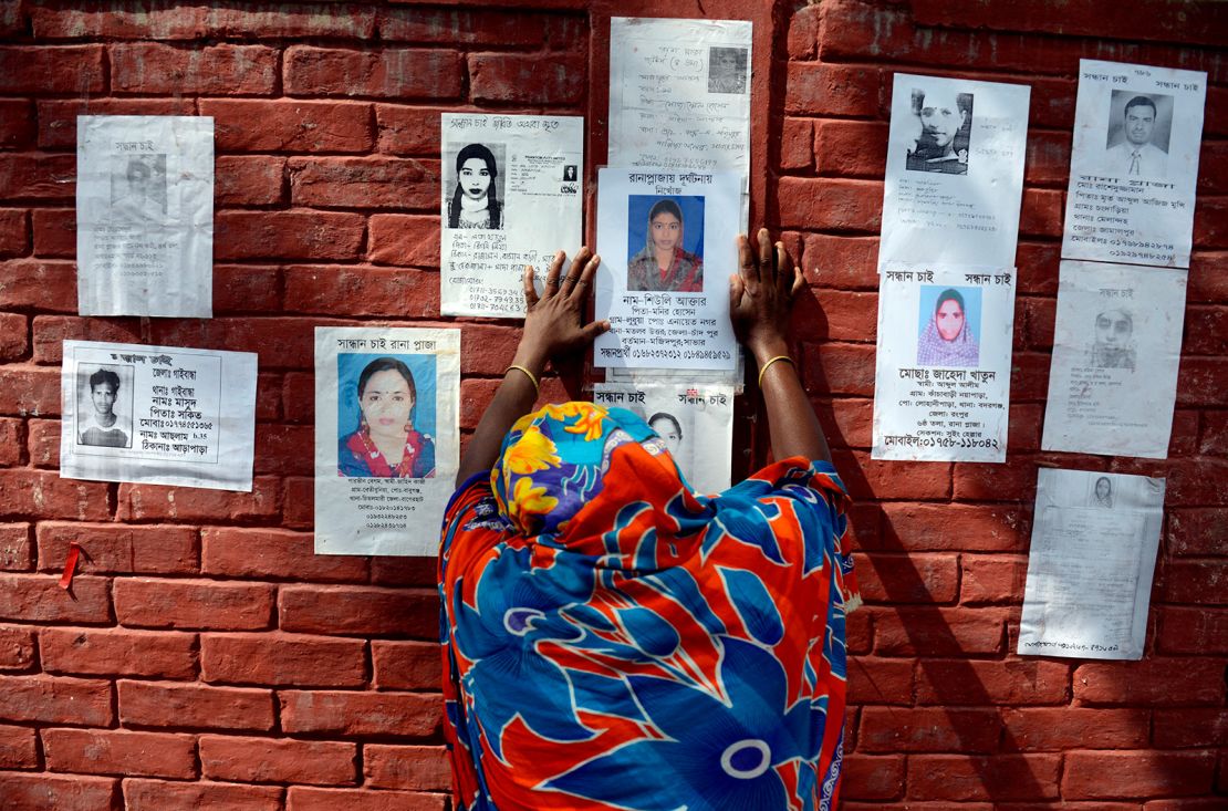 A woman grieves before a poster of her family member on the wall of a school turned into a make-shift morgue on April 30, 2013, following the Rana Plaza collapse in in Savar, near Dhaka, Bangladesh.
