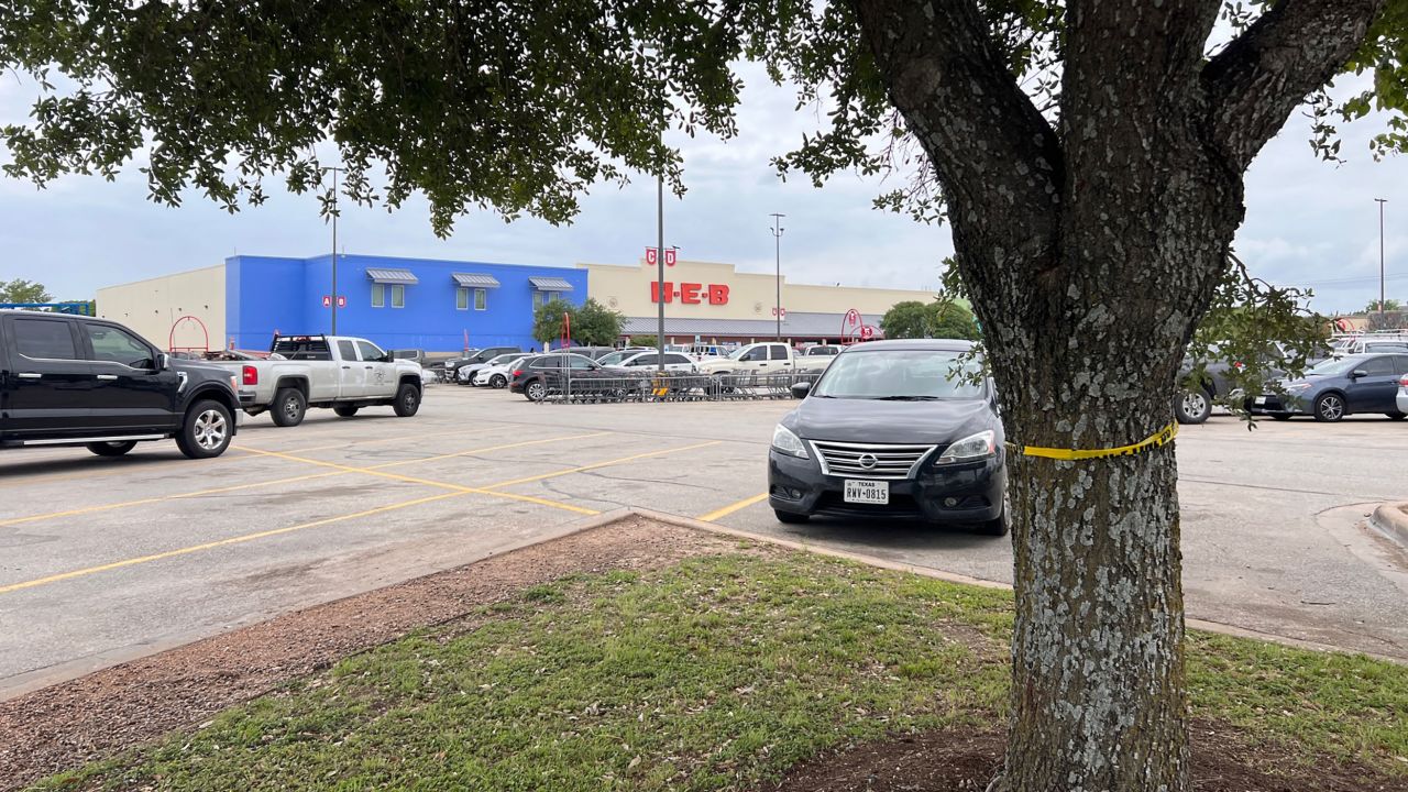 Crime scene tape is seen around a tree on Wednesday at the parking lot of the HEB where a shooting took place injuring two teenagers earlier in the week in Elgin, Texas.