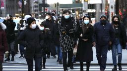 NEW YORK, NEW YORK - DECEMBER 06: People wearing protective masks cross a street in Midtown on December 6, 2020 in New York City. Many holiday events have been canceled or adjusted with additional safety measures due to the ongoing coronavirus (COVID-19) pandemic.