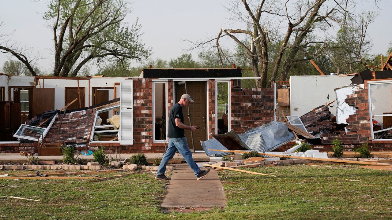A man walks through storm damage Thursday in Cole, Oklahoma.