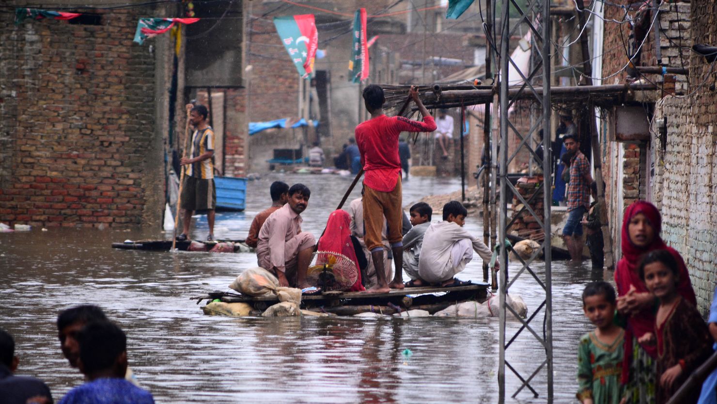 Residents use a raft to move along a waterlogged street in a residential area after a heavy monsoon rainfall in Hyderabad City, Pakistan, on August 19, 2022.
