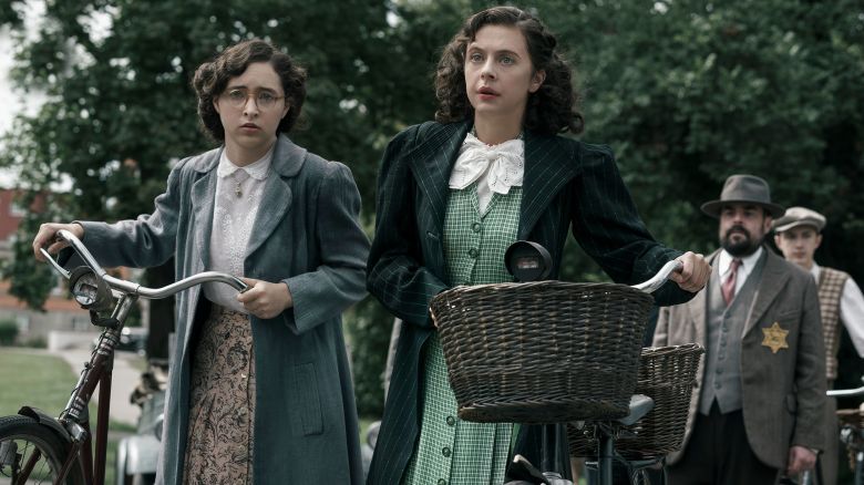 Margot Frank, played by Ashley Brooke, and Miep Gies, played by Bel Powley, arrive at a government checkpoint in A SMALL LIGHT. (Photo credit: National Geographic for Disney/Dusan Martincek)