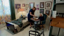 Tammy La Barbera gives her mother, Ada, a meal.