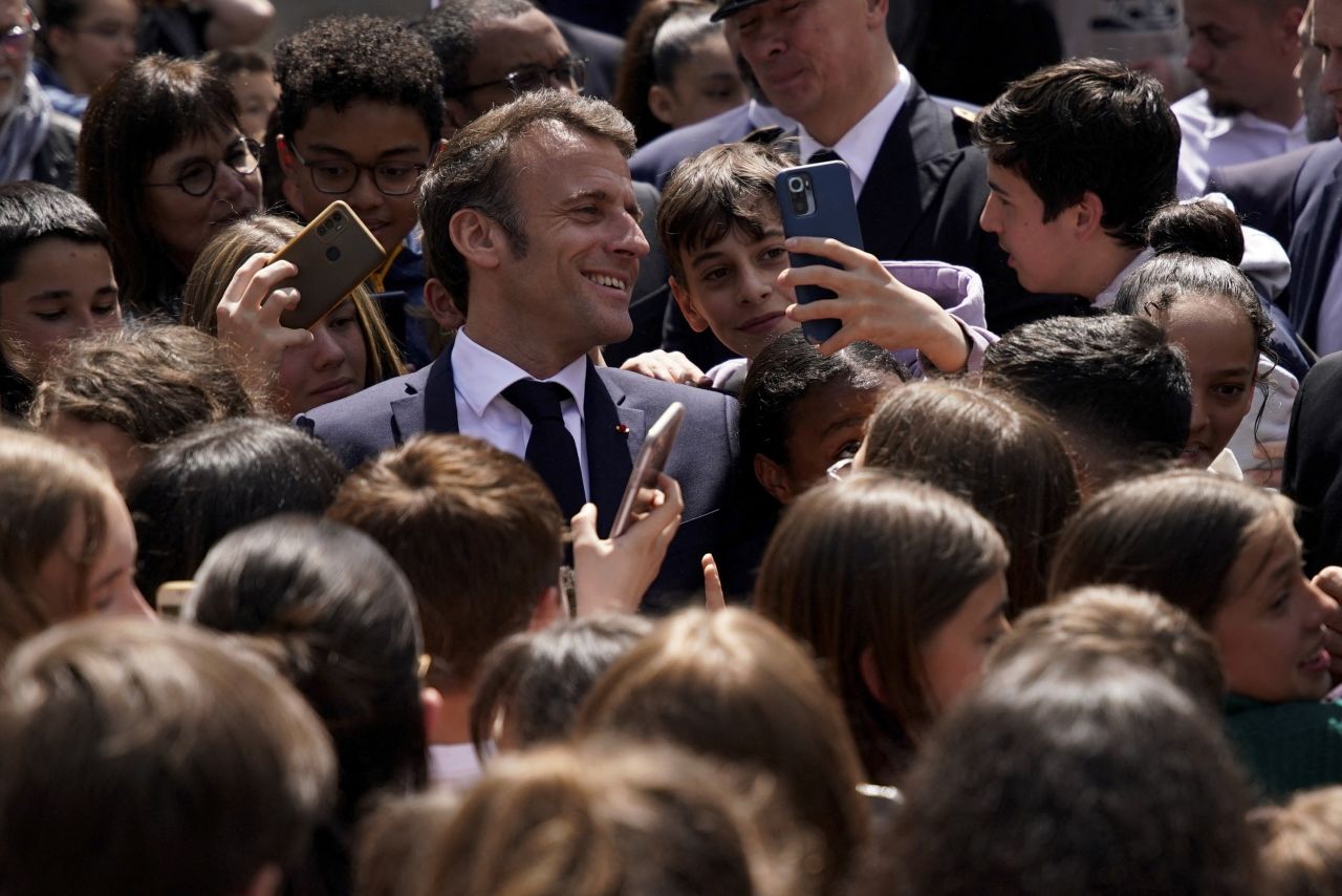 French President Emmanuel Macron poses for a selfie with schoolchildren as he visits a middle school in Ganges, France, on Thursday, April 20.
