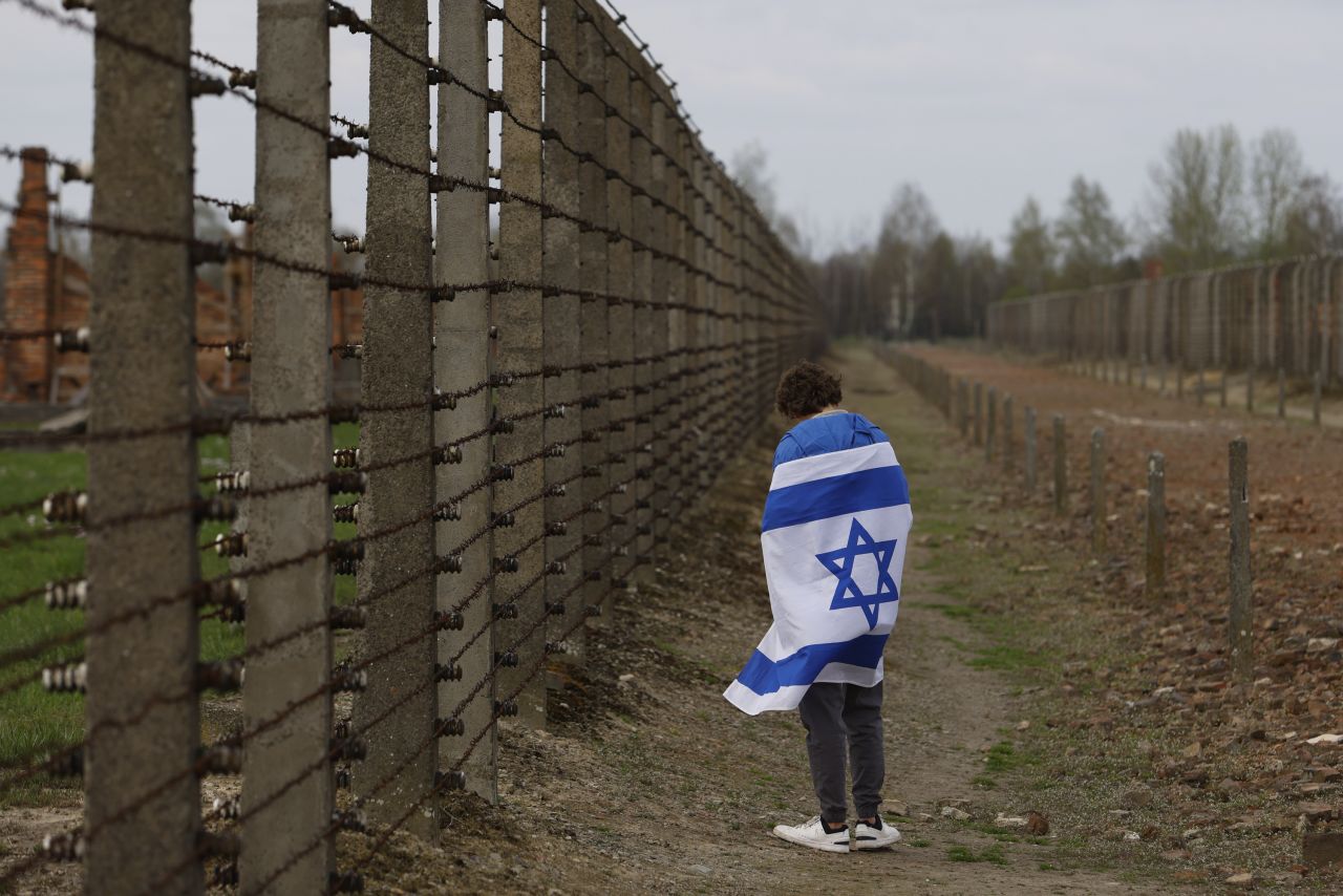 A man with an Israeli flag participates in the annual "March of the Living," a trek between two former Nazi-run death camps in Oświęcim, Poland, on Tuesday, April 18. Israel was marking its annual Holocaust Remembrance Day. <a href="http://www.cnn.com/2023/04/13/world/gallery/photos-this-week-april-6-april-13-ctrp/index.html" target="_blank">See last week in 32 photos</a>.