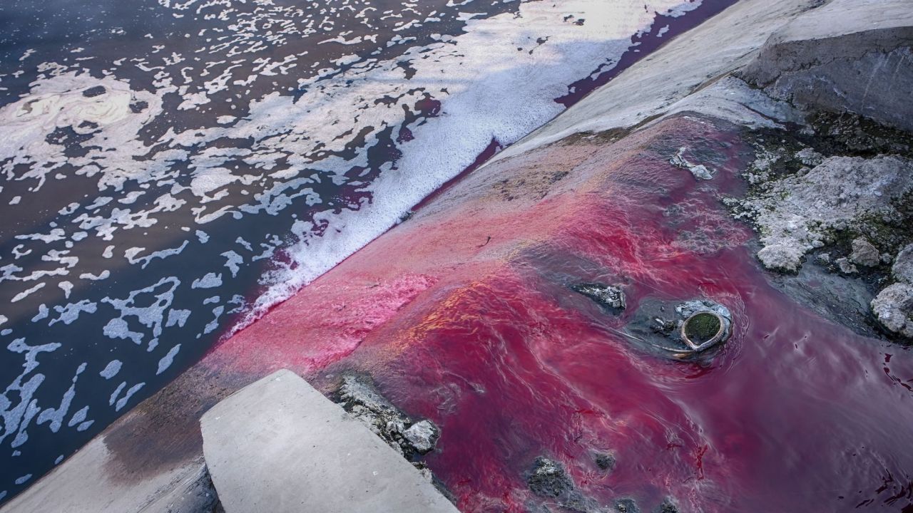 Textilabwasser enthält giftige Chemikalien aus Farbstoffen, die die Umwelt verschmutzen – wie Abwasser, das von Fabriken in den Dravyavati-Fluss in Indien eingeleitet wird (Bild).