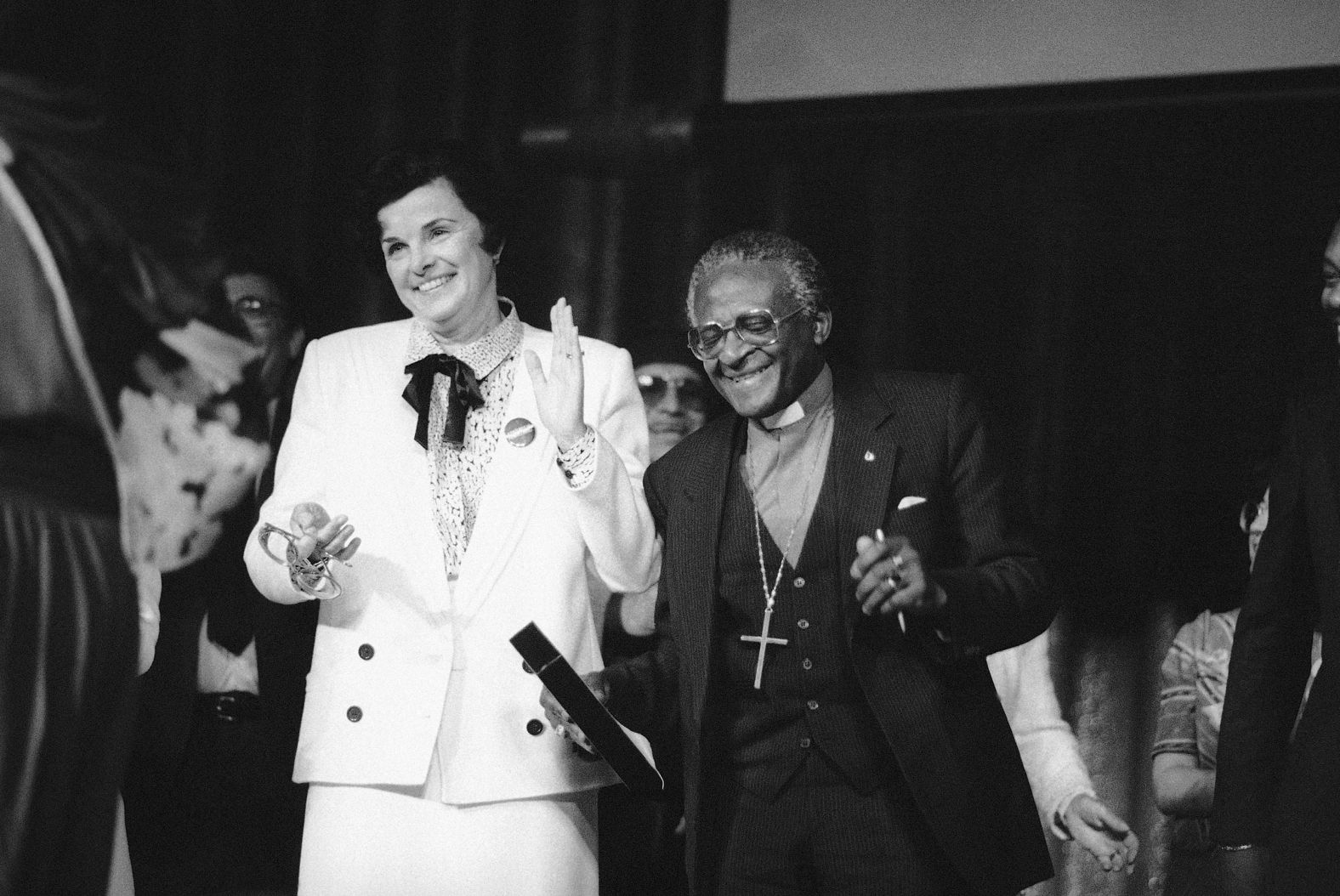 Feinstein and Bishop Desmond Tutu dance to the song "We Are The World" performed by a group of school children during a rally in San Francisco in 1985.