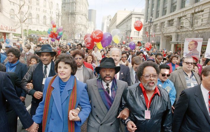 From left, Feinstein, California assembly speaker Willie Brown, and Rev. Cecil Williams hold hands during a march in honor of Dr. Martin Luther King Jr.  in San Francisco in 1986.
