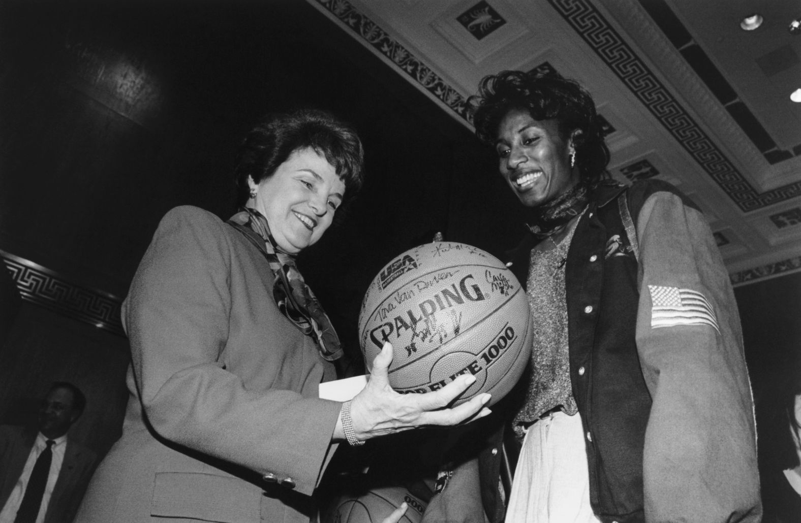 Feinstein is presented with a basketball by Lisa Leslie at a reception honoring the United States women's national basketball team in 1995.